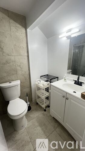 A bathroom with a toilet, sink, and a shower stool.