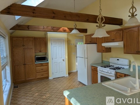 A kitchen with wooden cabinets and a white refrigerator.