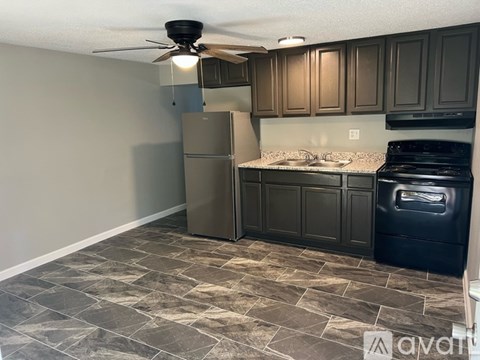 A kitchen with a refrigerator, oven, and sink.