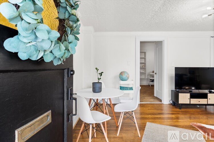 A modern living room with a black door, a white table, and a TV.