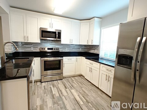 A kitchen with white cabinets and stainless steel appliances.