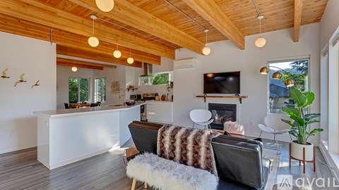 A living room with a white couch and a wooden ceiling.