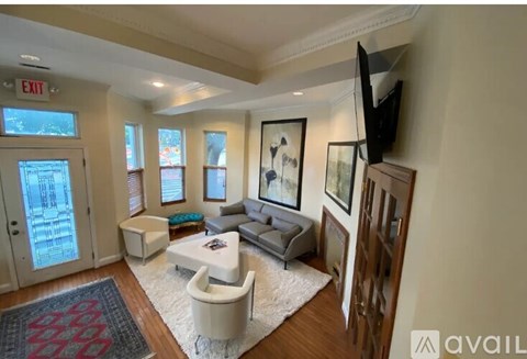 A living room with a grey couch and a white chair.