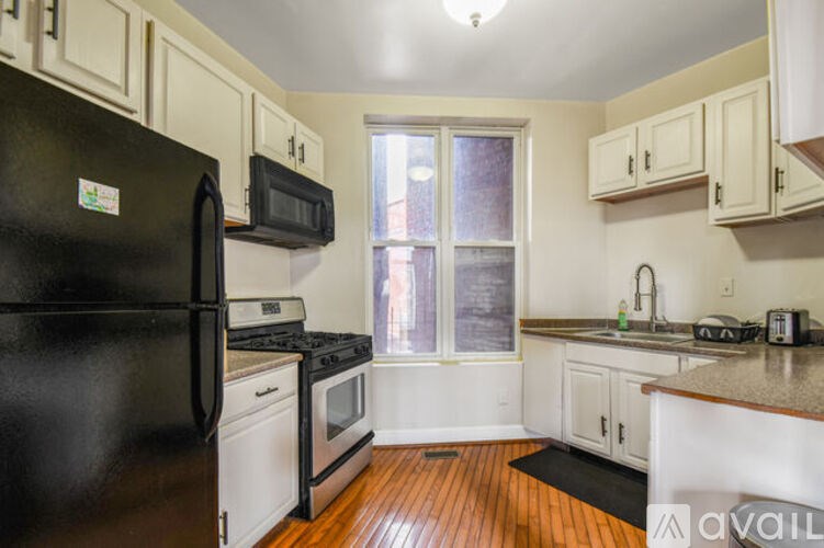 A kitchen with black appliances and white cabinets.