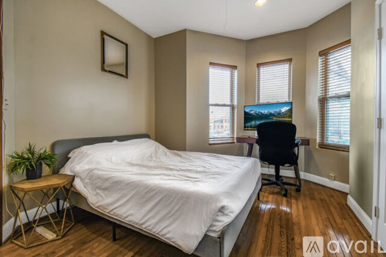 A bedroom with a bed, desk, and chair.