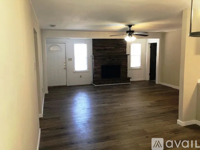 A living room with a fireplace and a ceiling fan.