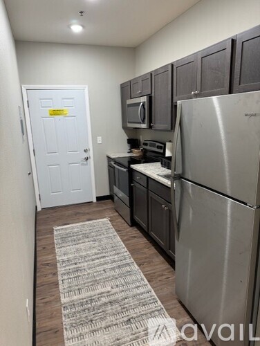 A kitchen with a refrigerator, microwave, and oven.