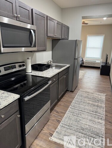A kitchen with a refrigerator, microwave, and oven.
