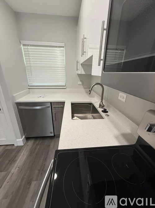 A modern kitchen with a stove, sink, and dishwasher.