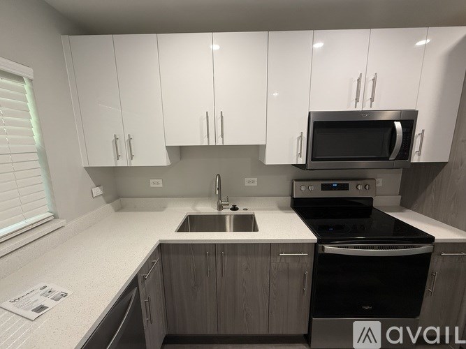 A modern kitchen with white cabinets and a black stove top oven.