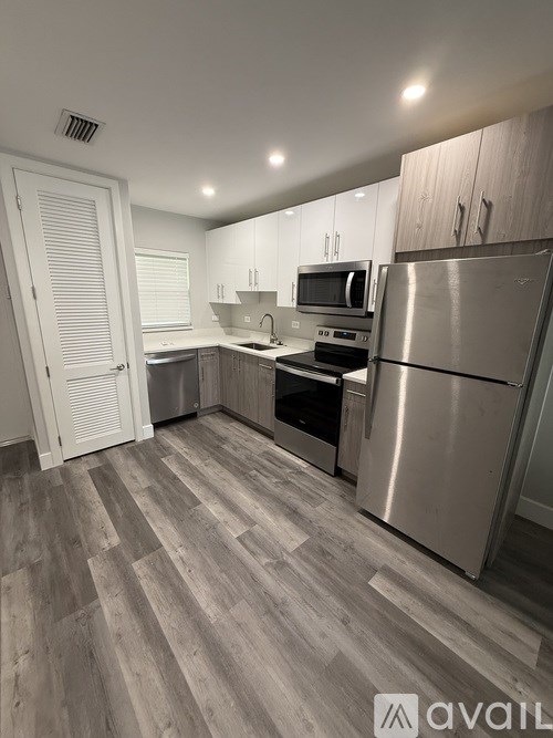 A kitchen with a stainless steel refrigerator, microwave, and oven.