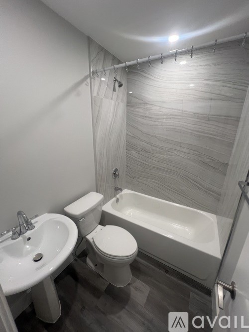 A bathroom with a white sink, toilet, and bathtub.