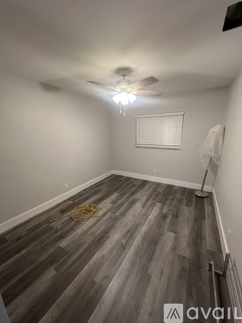 A room with wooden flooring and a ceiling fan.