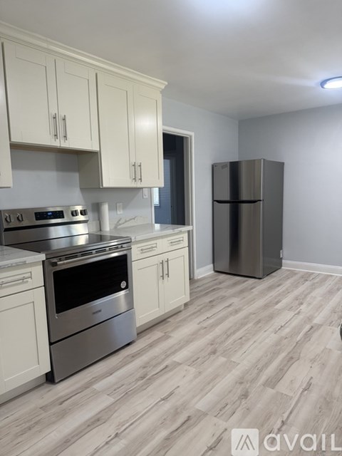 A kitchen with white cabinets and a stainless steel oven.