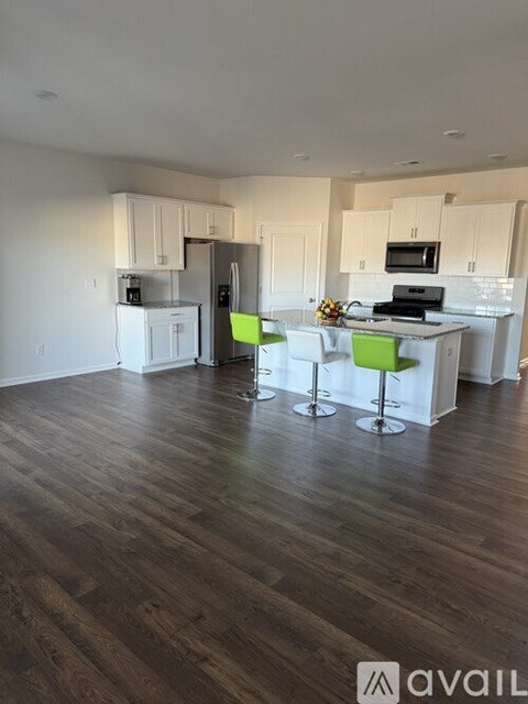 A kitchen with white cabinets and a wooden floor.