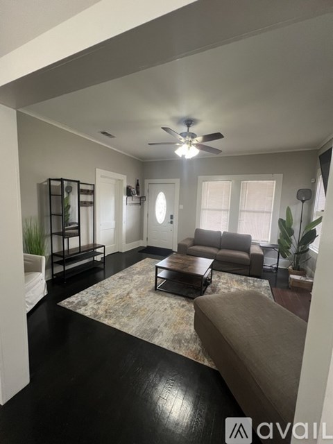 A living room with a brown couch and a rug.