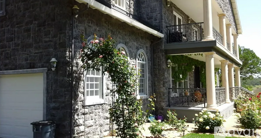 A house with a grey stone exterior and a white garage door.