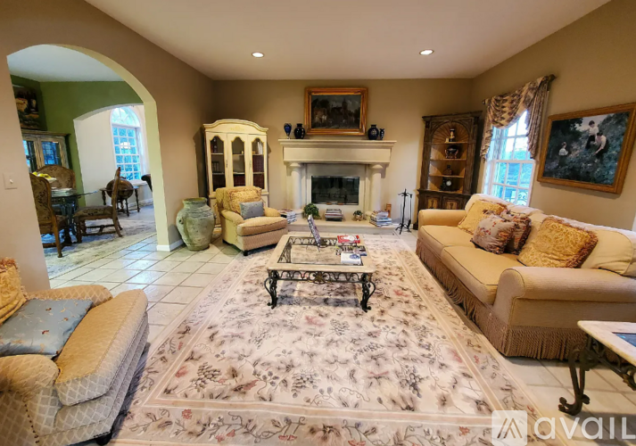 A living room with a fireplace and a large rug.