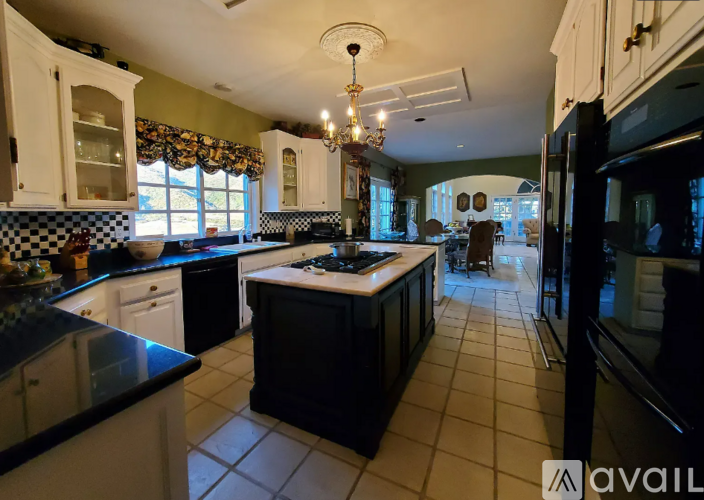 A kitchen with black countertops and white cabinets.
