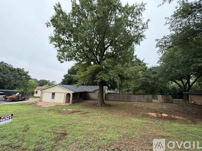 A house with a yard and a tree in front of it.