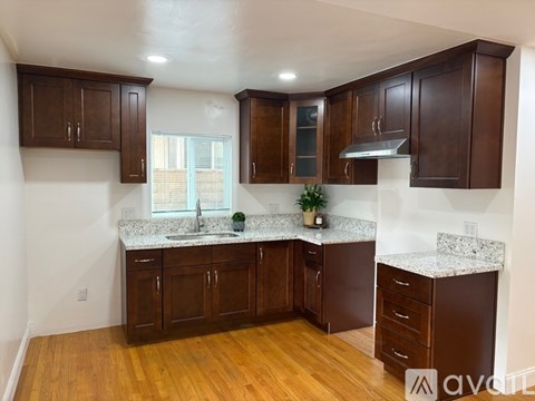 A kitchen with wooden cabinets and a granite countertop.