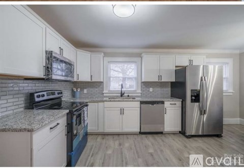 A kitchen with white cabinets and a granite countertop.