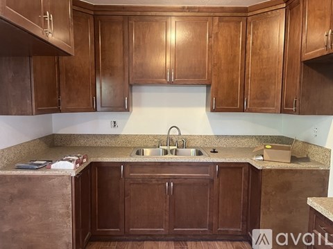 A kitchen with wooden cabinets and a granite countertop.
