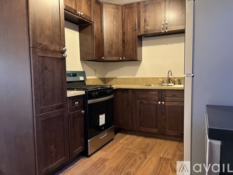 A kitchen with wooden cabinets and a black stove top oven.