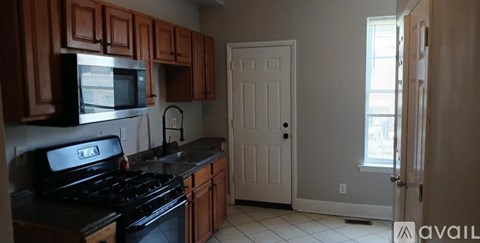 A kitchen with wooden cabinets and black appliances.