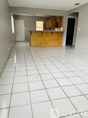 A kitchen area with a wooden island in the middle.