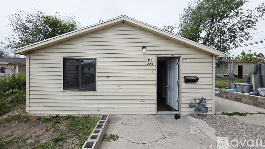 A small house with a white door and windows is for sale.
