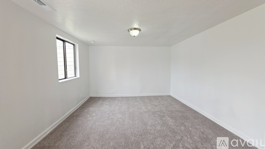 A room with a carpeted floor and a window.