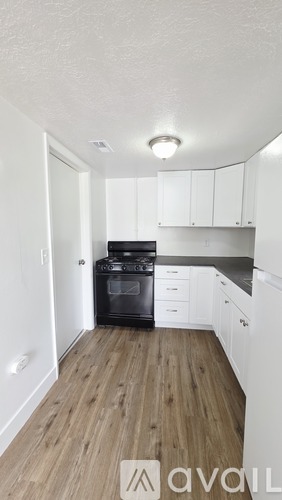 A kitchen with white cabinets and a black stove top oven.