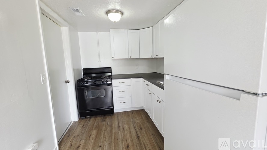 A kitchen with white cabinets and a black oven.