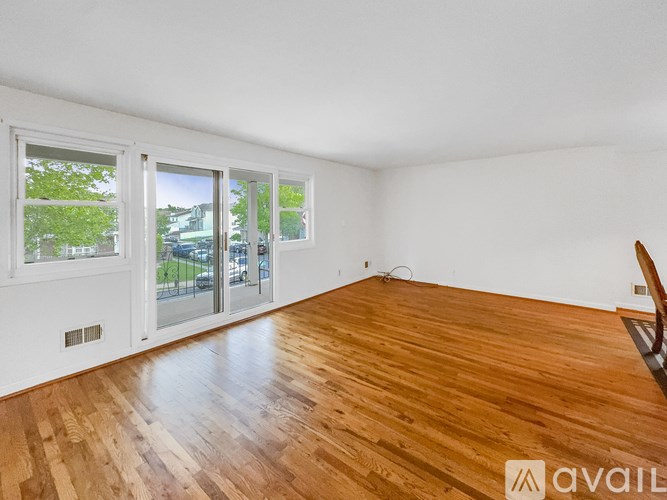 A room with wooden flooring and a window overlooking a street.