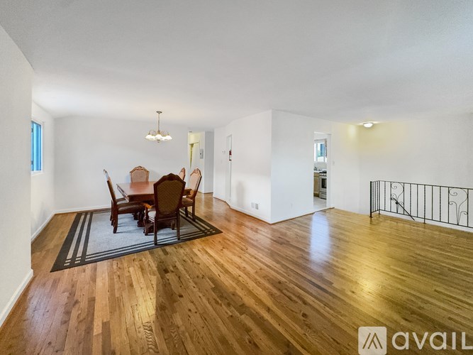 A room with wooden floors and a dining table set up.
