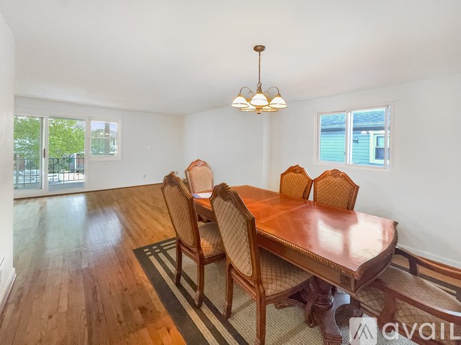 A dining room with a wooden table and chairs.