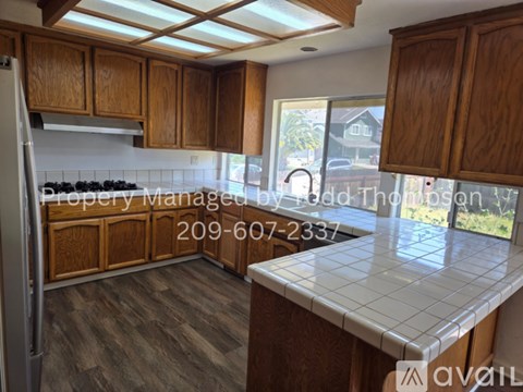 A kitchen with wooden cabinets and a tile countertop.