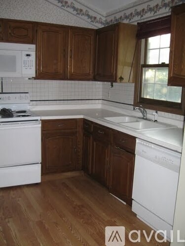 A kitchen with wooden cabinets and white appliances.