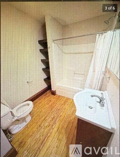 A small bathroom with a toilet, sink, and a shower with a white curtain.