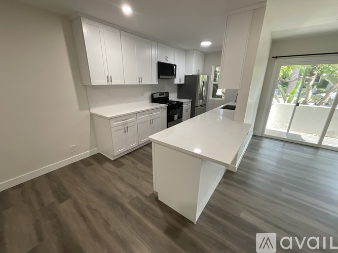 A modern kitchen with white cabinets and a large island.