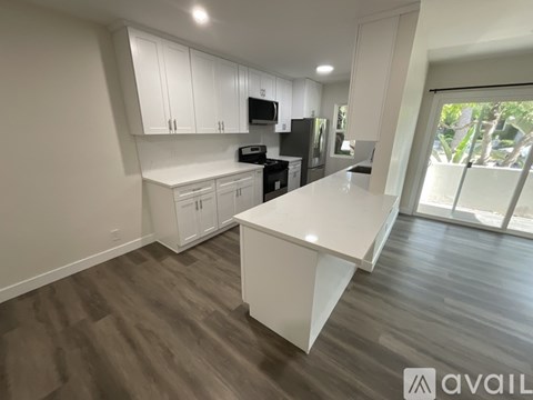 A modern kitchen with white cabinets and a large island.