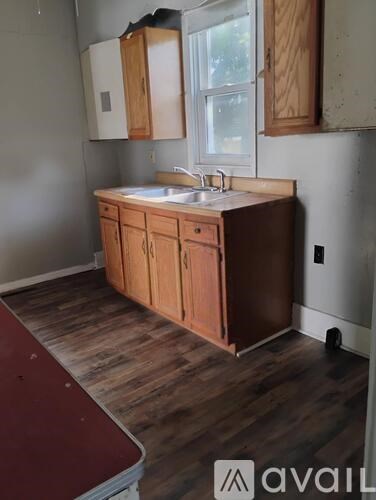A kitchen with wooden cabinets and a white sink.