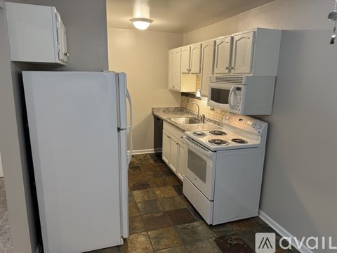 A kitchen with a white refrigerator and white oven.