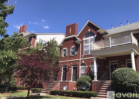 A large red brick house with a white porch.