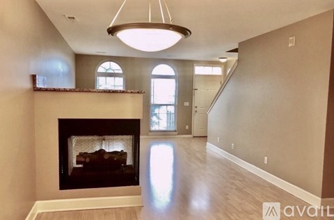 A living room with a fireplace and a chandelier.