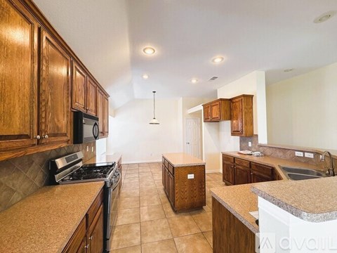 A kitchen with wooden cabinets and a granite countertop.