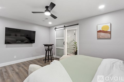 A living room with a white couch and a painting on the wall.