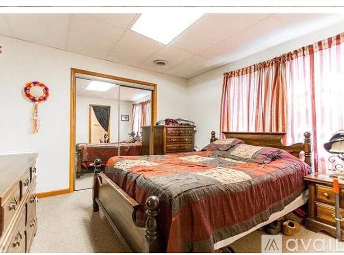 A bedroom with a large bed and a mirror on the wall.
