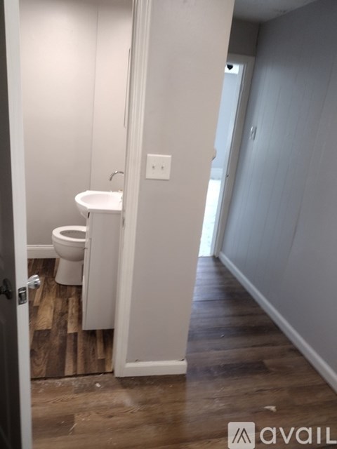 A room with a wooden door and a white chair.